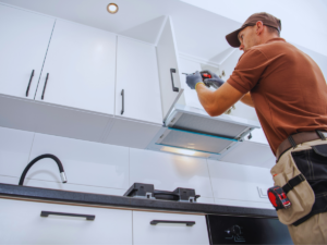 Remodeler installing frameless kitchen cabinets